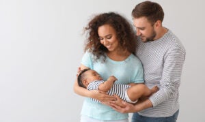 A family portrait showing a happy, interracial family on light background