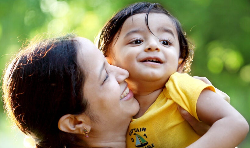 A mother kissing young child on the cheek