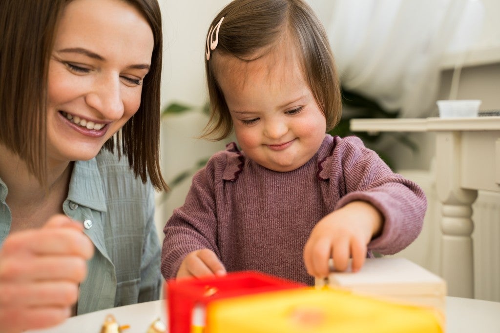 A mother with her special needs child having fun during play-time