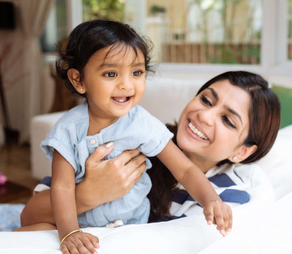 A young Indian mother with her small daughter having a playful moment