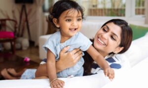 A young Indian mother with her small daughter having a playful moment