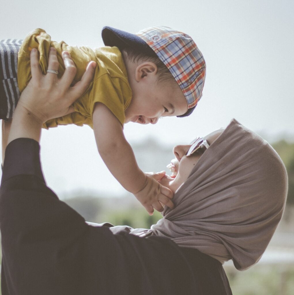 Woman In Head Scarf Playing With Baby