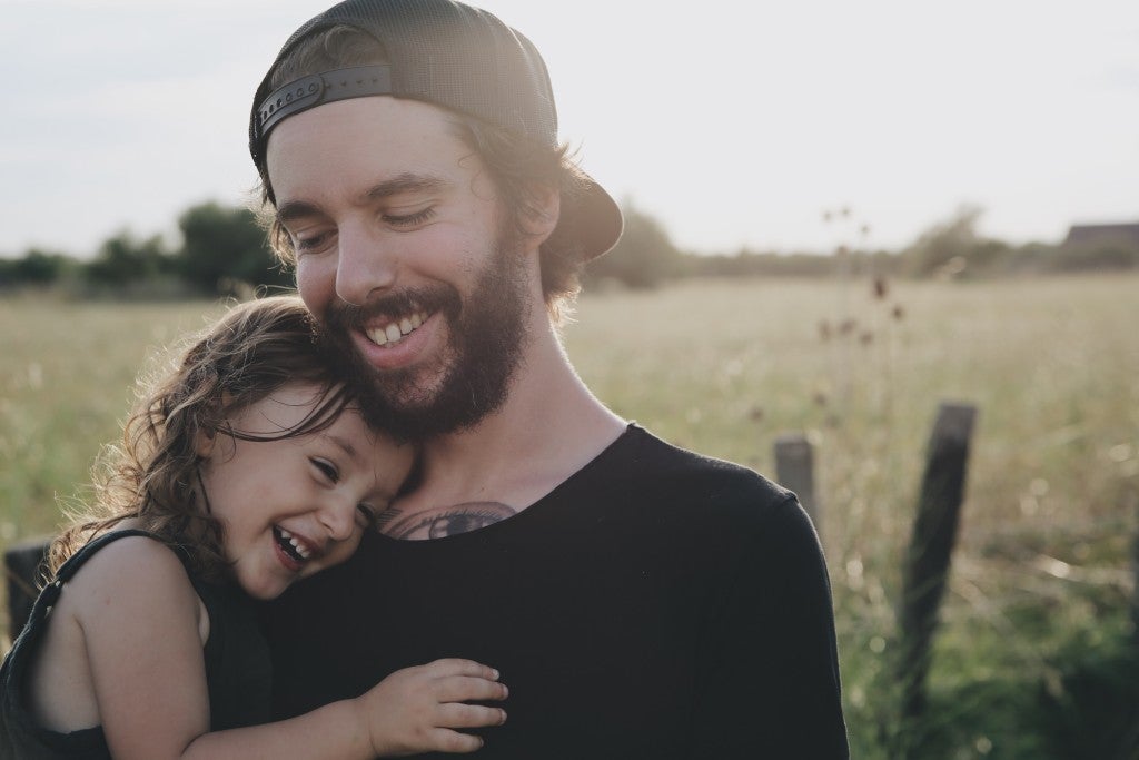 A young father holding his toddler daughter